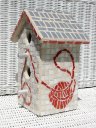 White bird house with red ball of yarn on side mosaic