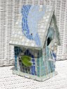 Gray bird house with blue dolphin jumping over top mosaic