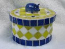 Round yellow and white box with blue pig on top mosaic